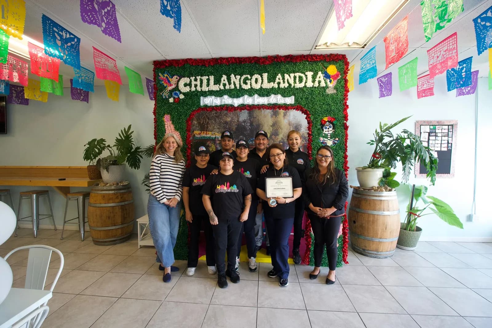 The Chilangolandia team together under colorful papel picado banners inside the shop.